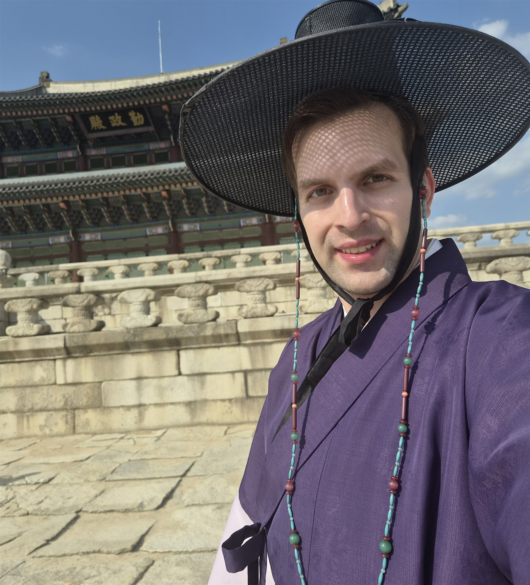 Jozef Podhajecky wearing traditional Korean clothing in front of a palace